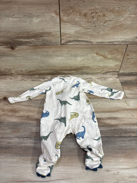 Top view of Child Of Mine sleeper showcasing dinosaur print, long sleeves, and footed design on a wood floor