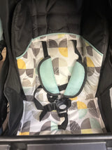 Close-up of Baby Trend EZ Ride Stroller in Doodle Dots showcasing patterned seat, five-point harness, and mint shoulder pads