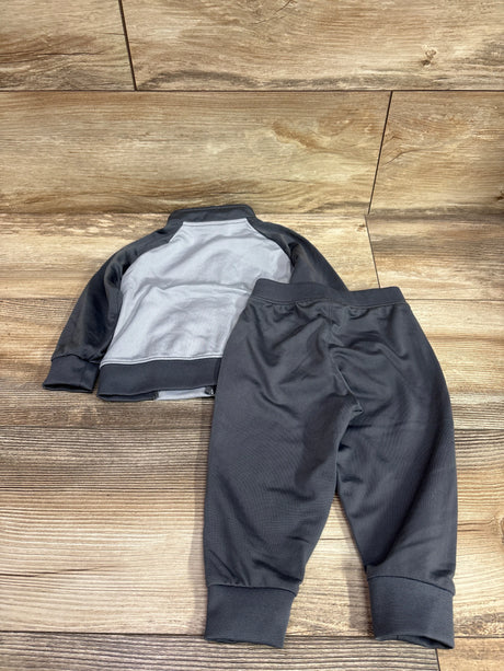 Nike 2pc Tracksuit in grey and black for size 12m baby, laid on a wooden background