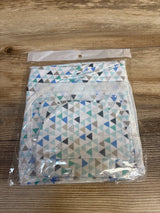 Top-down view of newborn swaddle wrap and matching hat showing blue, teal and gray triangle pattern in clear packaging on wooden surface