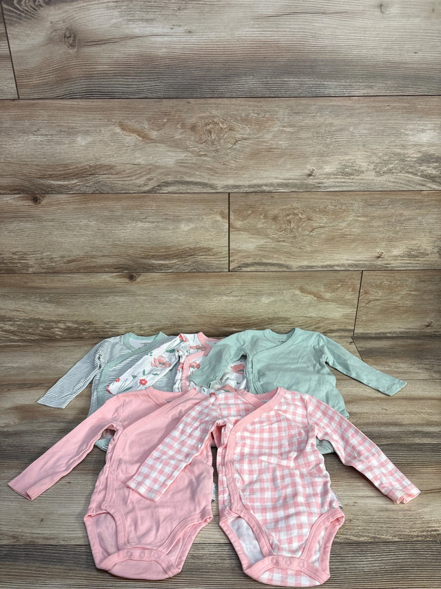 Front laid-flat view of Butterblu 5-pack kimono bodysuits, assorted pink and green prints, long sleeves and snap crotch, on wood background, size 6 to 9 months