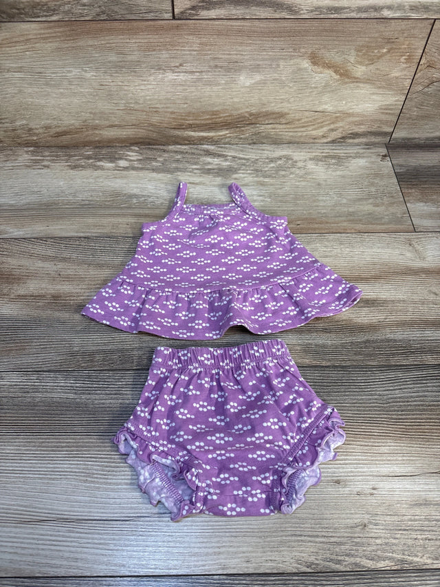 Purple baby girl outfit with white polka dot pattern, top and ruffled bloomers on wood floor