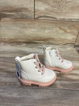Front-side view of Cat & Jack Amaya toddler combat boots in cream with pink laces and pink lug sole showing side zipper on wood background