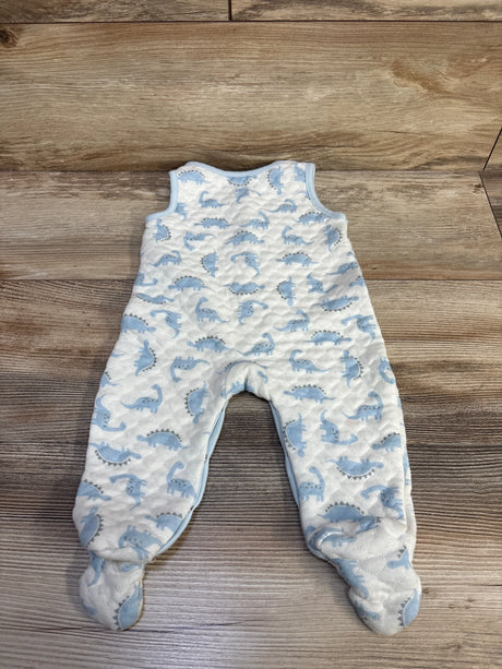 Flat lay of Minibean white footed jumpsuit showing blue dinosaur print and quilted texture on wood background, size 6-9 months