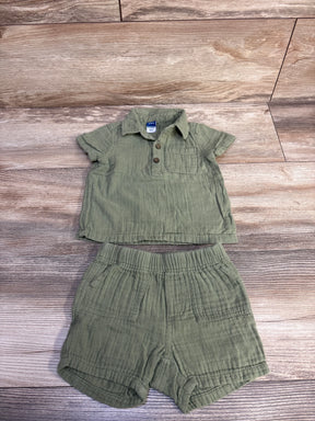 Flat lay of green Old Navy gauze henley shirt and elastic shorts showing button placket, chest pocket on wood background
