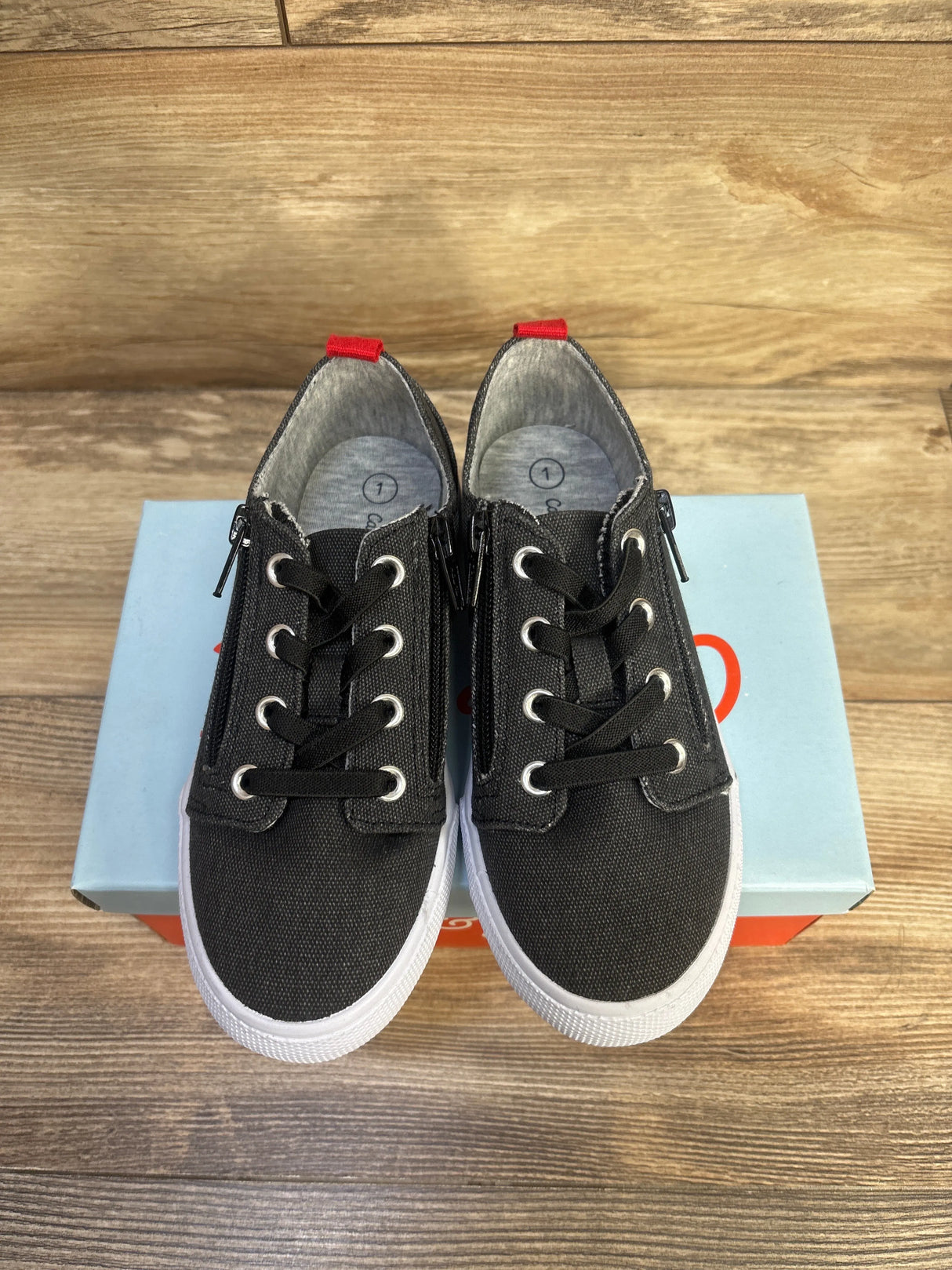 Top view of Cat and Jack Lucian toddler sneakers showing grey canvas, double side zippers and elastic laces on a shoebox
