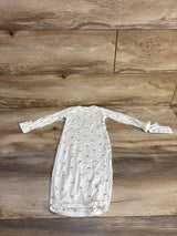 Flat-lay of Carter's white baby gown showing tan snail print, long sleeves, and elastic hem on wood background