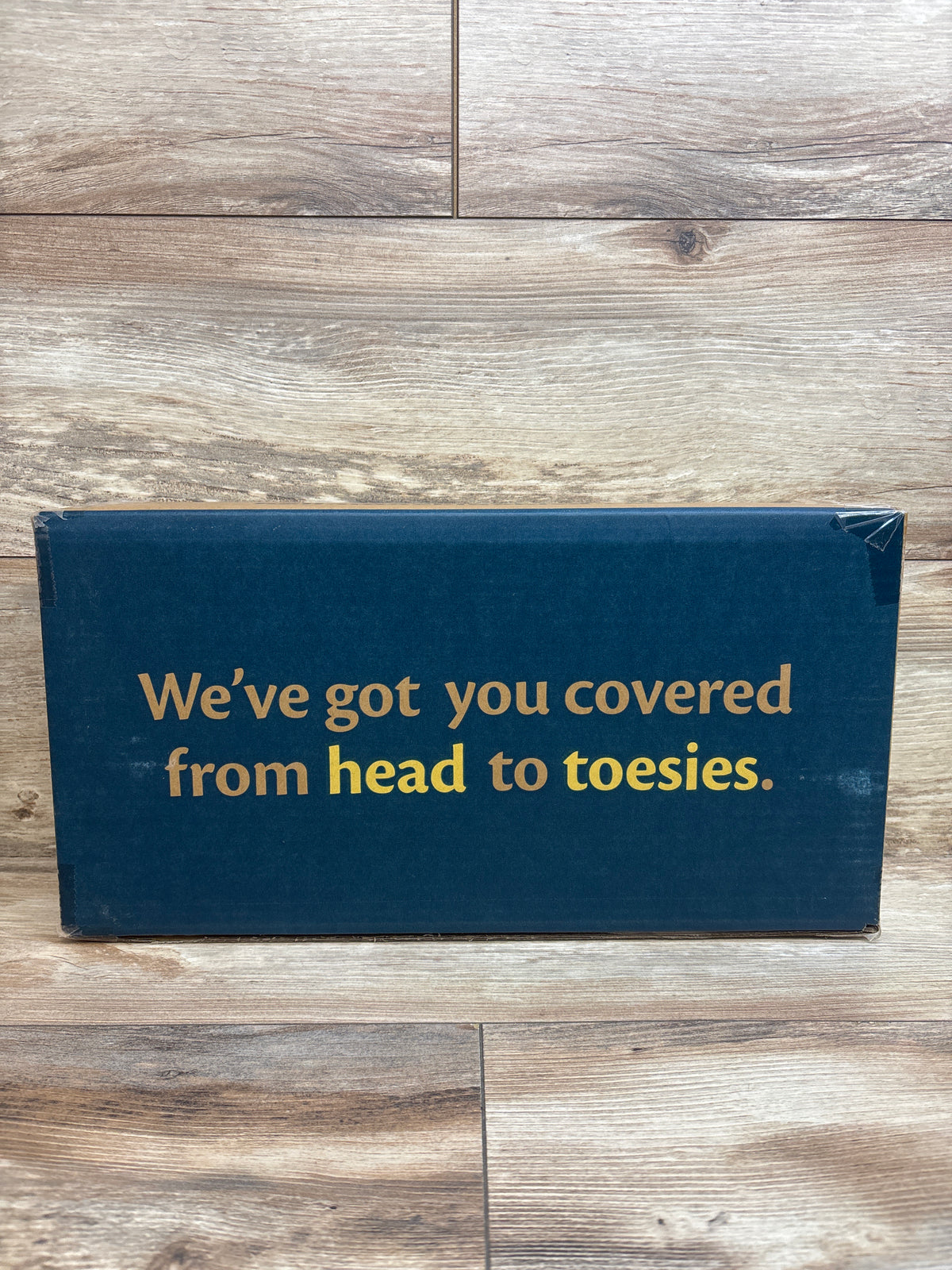 Mockingbird snack tray packaging with the text We’ve got you covered from head to toesies on a wood floor