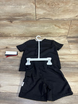 Flat lay of toddler Reebok black short-sleeve shirt and elastic-waist shorts showing side cargo pocket on wood background