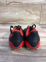 Rear view of Adidas Predator 20.4 FXG toddler soccer cleats showing black and red upper, heel pull loops, and studded outsole on wood floor