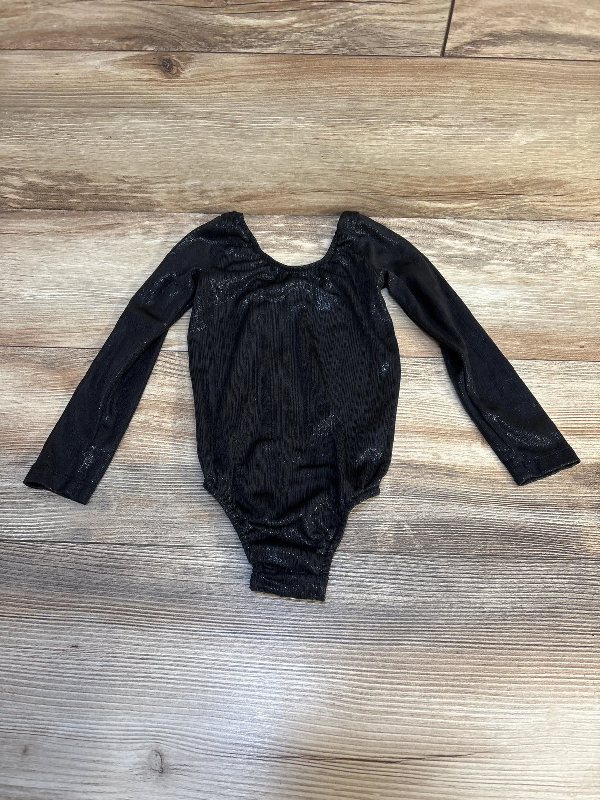Black long sleeve children's leotard on wood background, gently used kids clothing