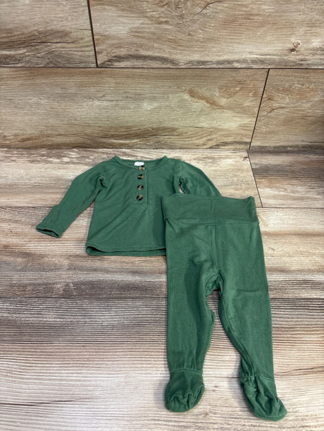 Top view of Lou Lou 2pc Henley Top and Pants in green, size newborn, showing four-button front and footed pants on a wood floor