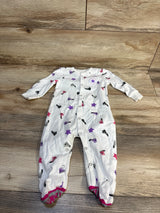 White baby onesie with Converse sneaker and star print, footed design, laid on wood floor