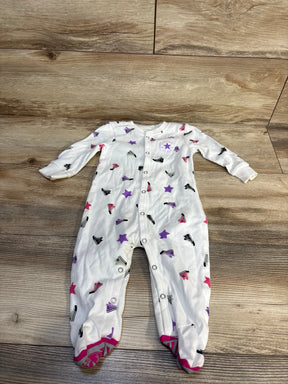 White baby onesie with Converse sneaker and star print, footed design, laid on wood floor