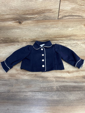 Navy blue baby jacket with white trim and buttons on wood background