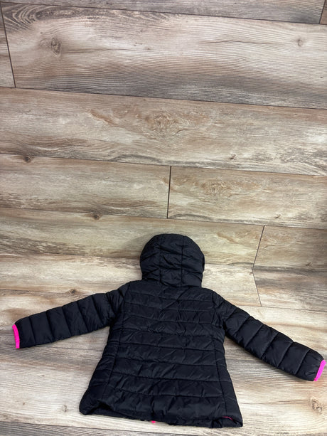 Back view of black Nike hooded puffer jacket in size 2T showing quilted panels and pink cuff lining on wood floor