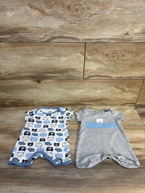 Baby onesies with bear prints and 'BEAR' text on wooden floor