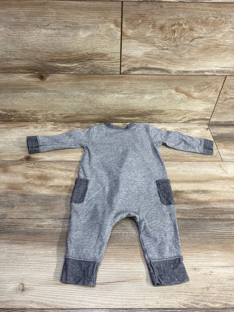 Gray long-sleeve baby jumpsuit with striped cuffs and pockets on wood floor background