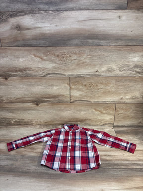 Front view of U.S. Polo Assn. toddler button-up shirt laid flat showing red plaid and chest pocket on wood background