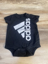Black short sleeve baby bodysuit with white logo graphic on wooden background