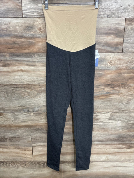 Folded maternity leggings with beige high waist and dark gray legs on wood background