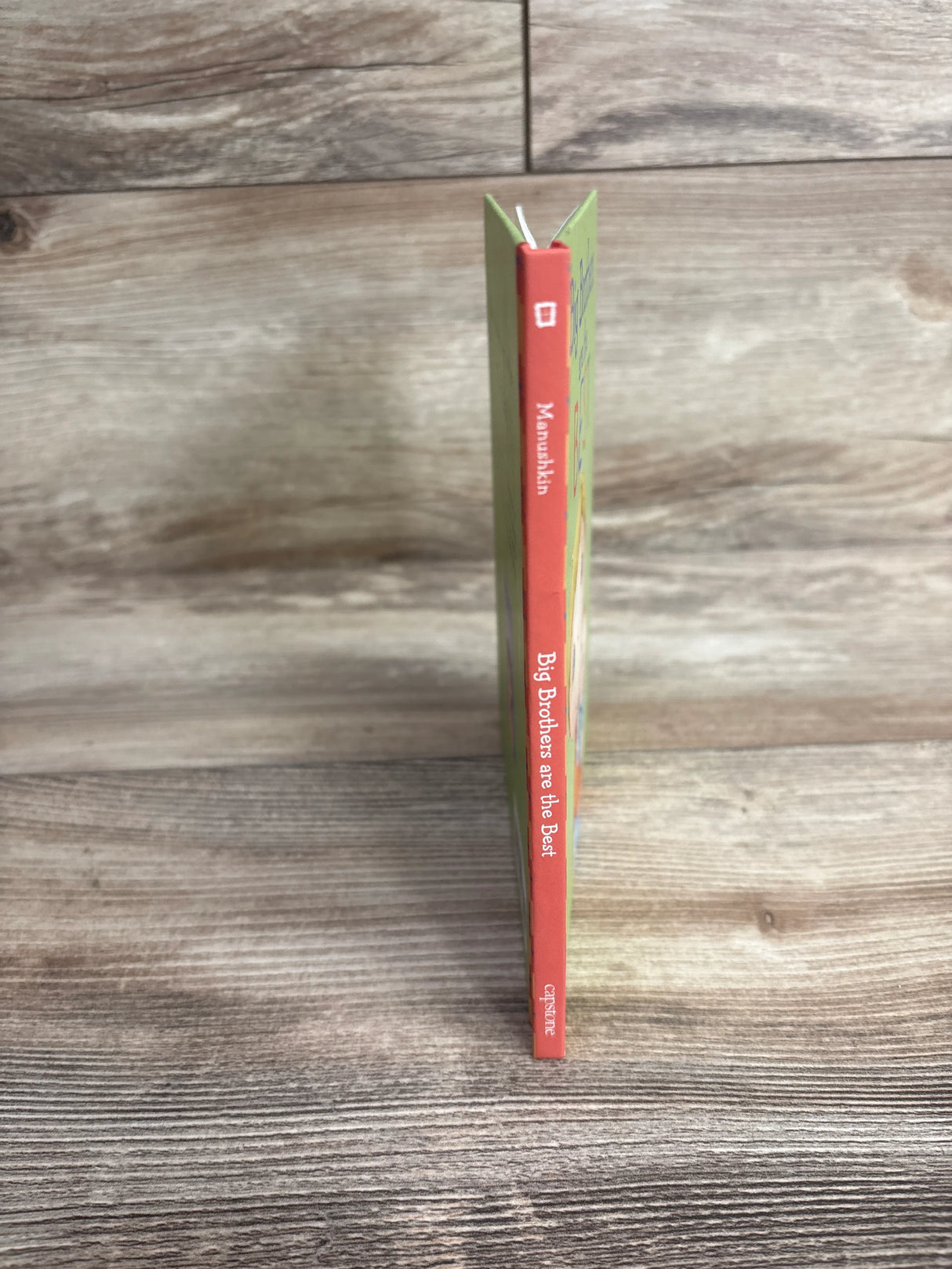 Children's book titled Big Brothers are the Best by Manushkin on wooden surface