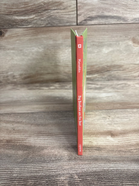 Children's book titled Big Brothers are the Best by Manushkin on wooden surface