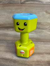 Angled front view of Fisher-Price Laugh & Learn Countin' Reps green dumbbell rattle showcasing smiling face, textured grip, and orange music button on a wood surface background