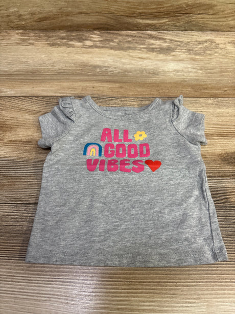 Front view of gray Okie Dokie baby shirt in size 3 months showcasing All Good Vibes graphic with rainbow and heart on wood background