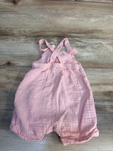 Top-down Baby Gap pink gauze shortalls 12–18M with crisscross straps, elastic waist, rolled leg hems on wood floor