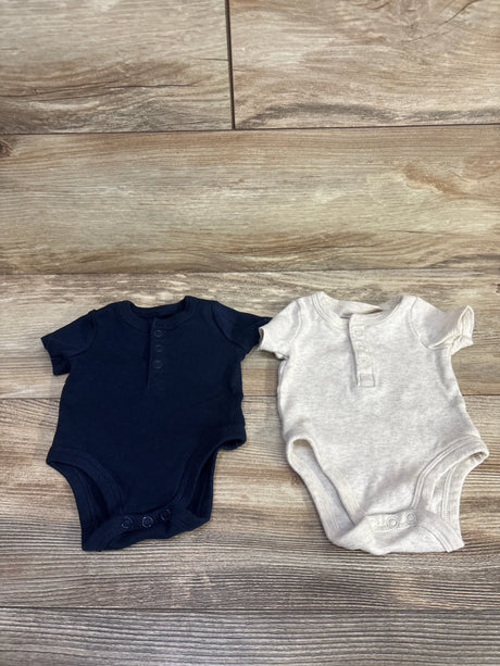 Flat lay of Amazon Essentials 2pc newborn Henley bodysuits navy and beige with front buttons and snap crotch on wood