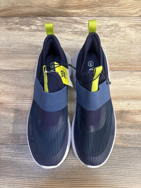 Top view of All In Motion navy slip-on sneakers with elastic strap and lime green heel tabs, size 6Y on wood floor