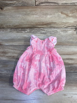 Front flat lay of pink tie-dye shortie romper with ruffle shoulders, gathered waist and elastic leg openings on wood