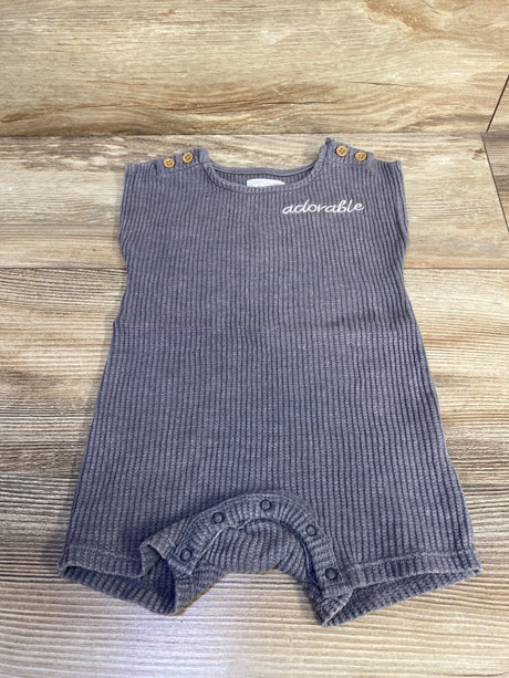 Flat lay of Grayson mini knit romper showcasing ribbed grey knit, adorable embroidery, shoulder wooden buttons and crotch snap closures on light wood background