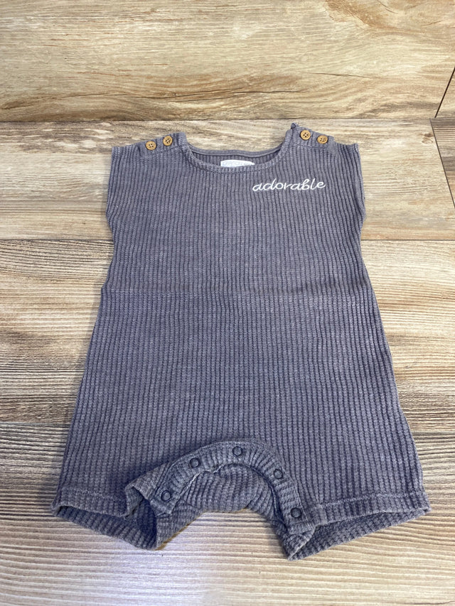 Flat lay of Grayson mini knit romper showcasing ribbed grey knit, adorable embroidery, shoulder wooden buttons and crotch snap closures on light wood background