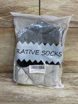 Front view of 12-pack RATIVE non-skid baby crew socks showcasing white grippy dots on gray and cream with wood background