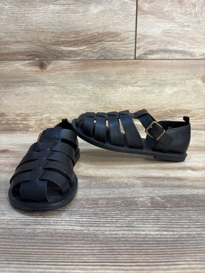 Black kids’ leather fisherman sandals with buckle on wood floor