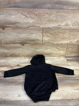 Back view of black hooded sweatshirt bubble romper with long sleeves on a wood-look floor