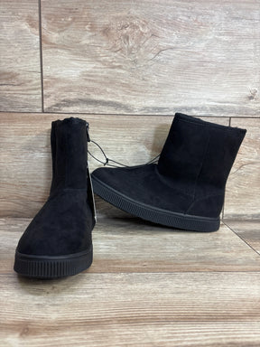 Pair of black suede children's boots with rubber soles on wood floor