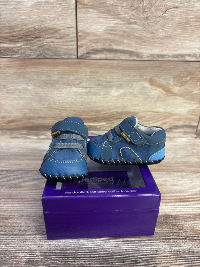 Front and side view of Pediped Dani navy crib shoes showing soft leather sole and Velcro strap on purple box and wood
