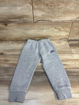 Gray Nike toddler sweatpants with purple logo, laid flat on wood floor for kids clothing resale