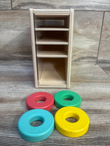 Front view of Lovevery Count & Slide Ring Chute showing four colorful wooden rings and chute shelves on a wood tabletop