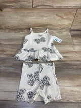 Flat lay of cream ribbed tank and shorts set, size 12m, showing black butterfly print, peplum tank and ruffled shorts on wood