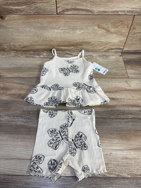 Flat lay of cream ribbed tank and shorts set, size 12m, showing black butterfly print, peplum tank and ruffled shorts on wood