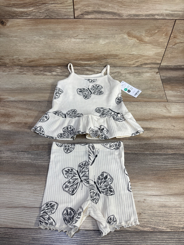 Flat lay of cream ribbed tank and shorts set, size 12m, showing black butterfly print, peplum tank and ruffled shorts on wood