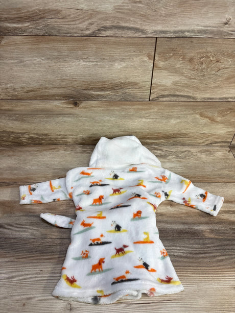 Flat lay of white baby plush robe with multicolored dog print and hood showing long sleeves and tail on wood background