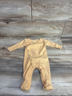 Neutral beige ribbed baby footed romper with side buttons on wood background