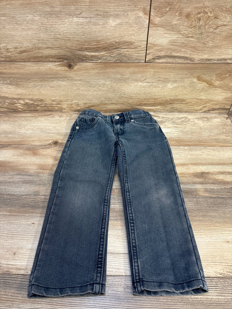 Children's dark wash denim jeans laid flat on wood floor