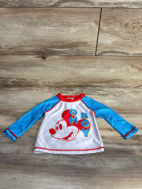 Front view of baby rashguard with large red Mickey face and OH BOY graphic, blue raglan sleeves and red trim on wood floor
