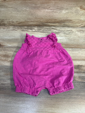 Top down view of Just One You romper in pink with eyelet lace yoke, ruffle sleeves and snap leg closures on wood background
